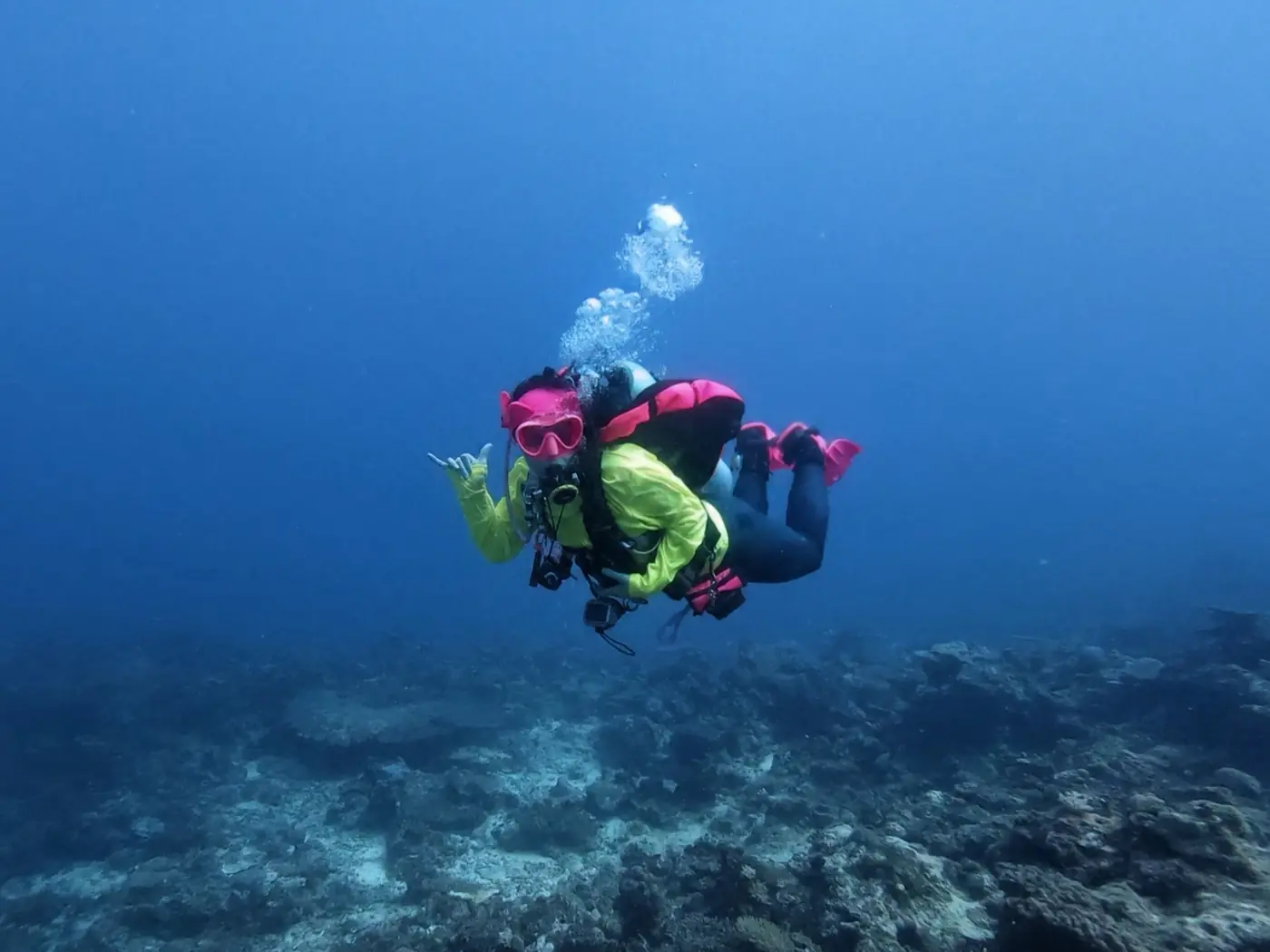 Allie swimming in blue water off Sharm el-Sheikh, Egypt, giving a shaka
