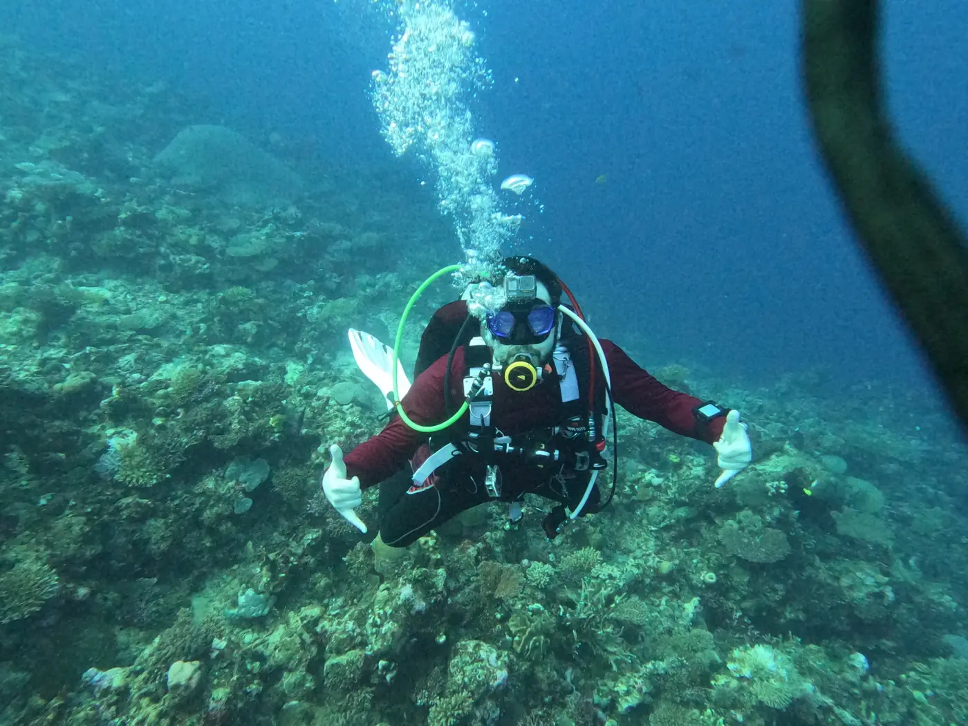 Eric giving shakas over a sloping coral reef