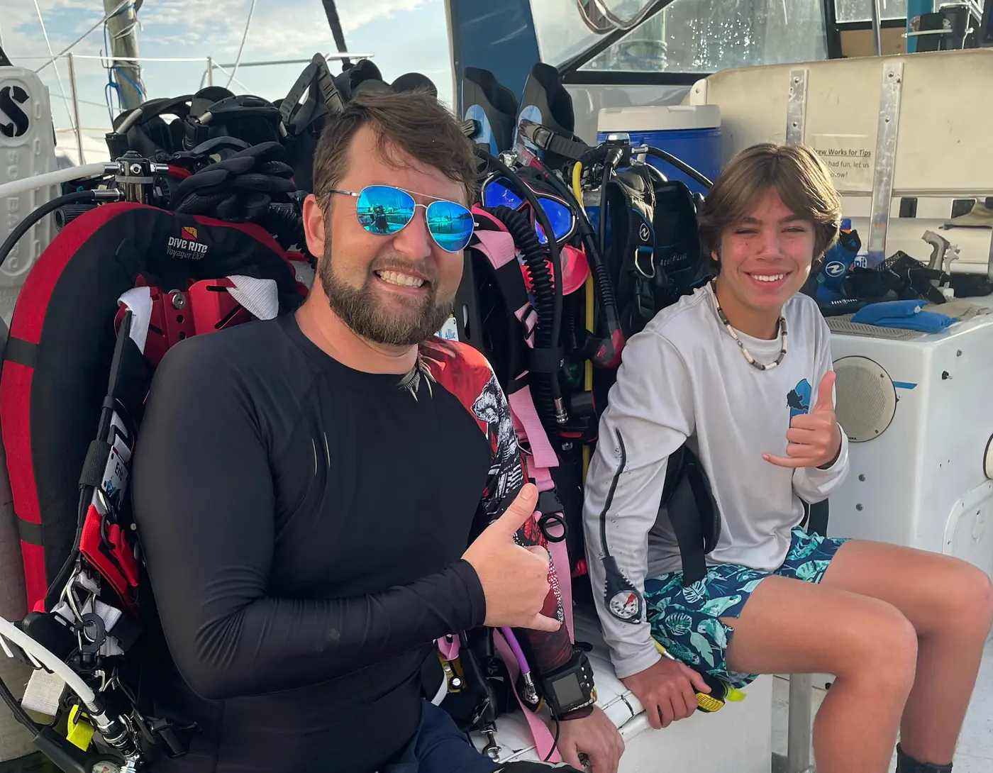 Eric and family giving shakas on a dive boat among the gear off Tampa, Florida